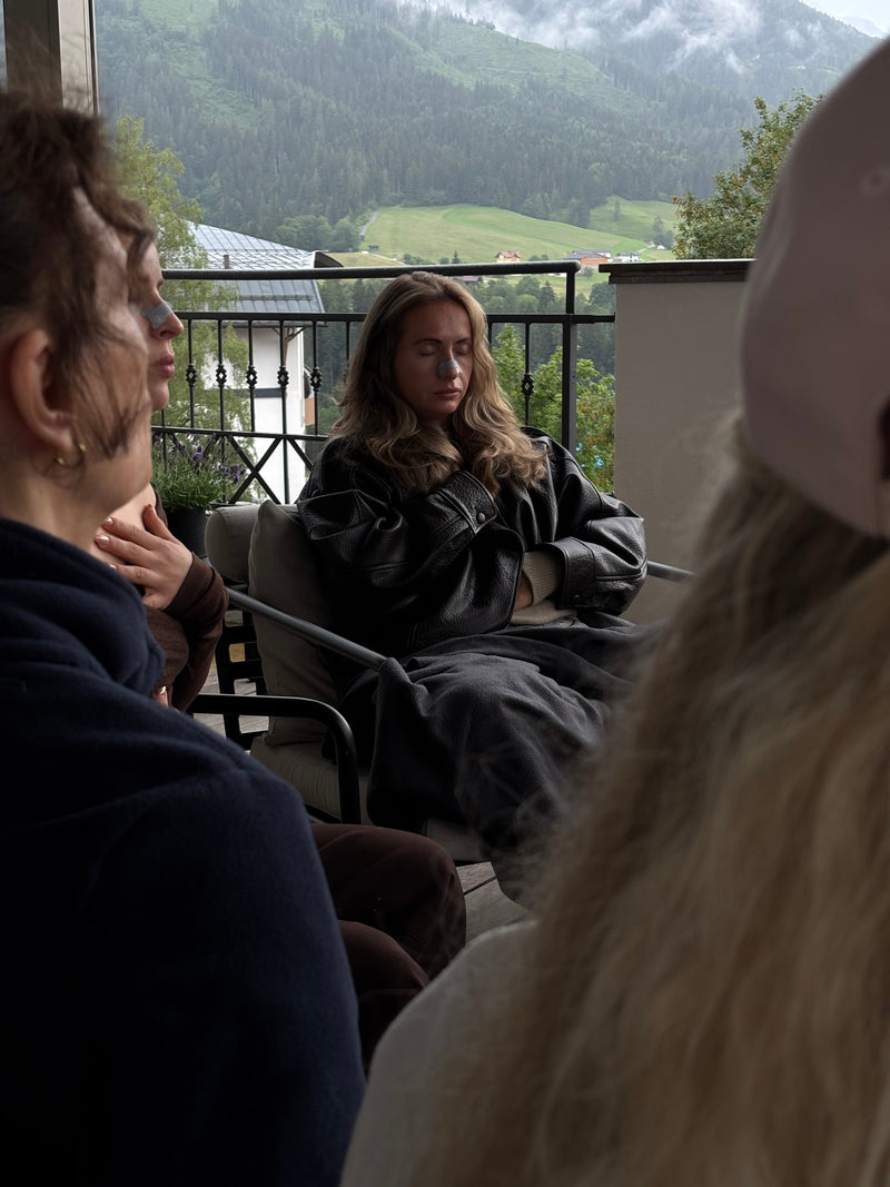 Audemu Breathwork-Teilnehmerin in tiefer Meditation mit Audemu Nasal Strip, Bergpanorama