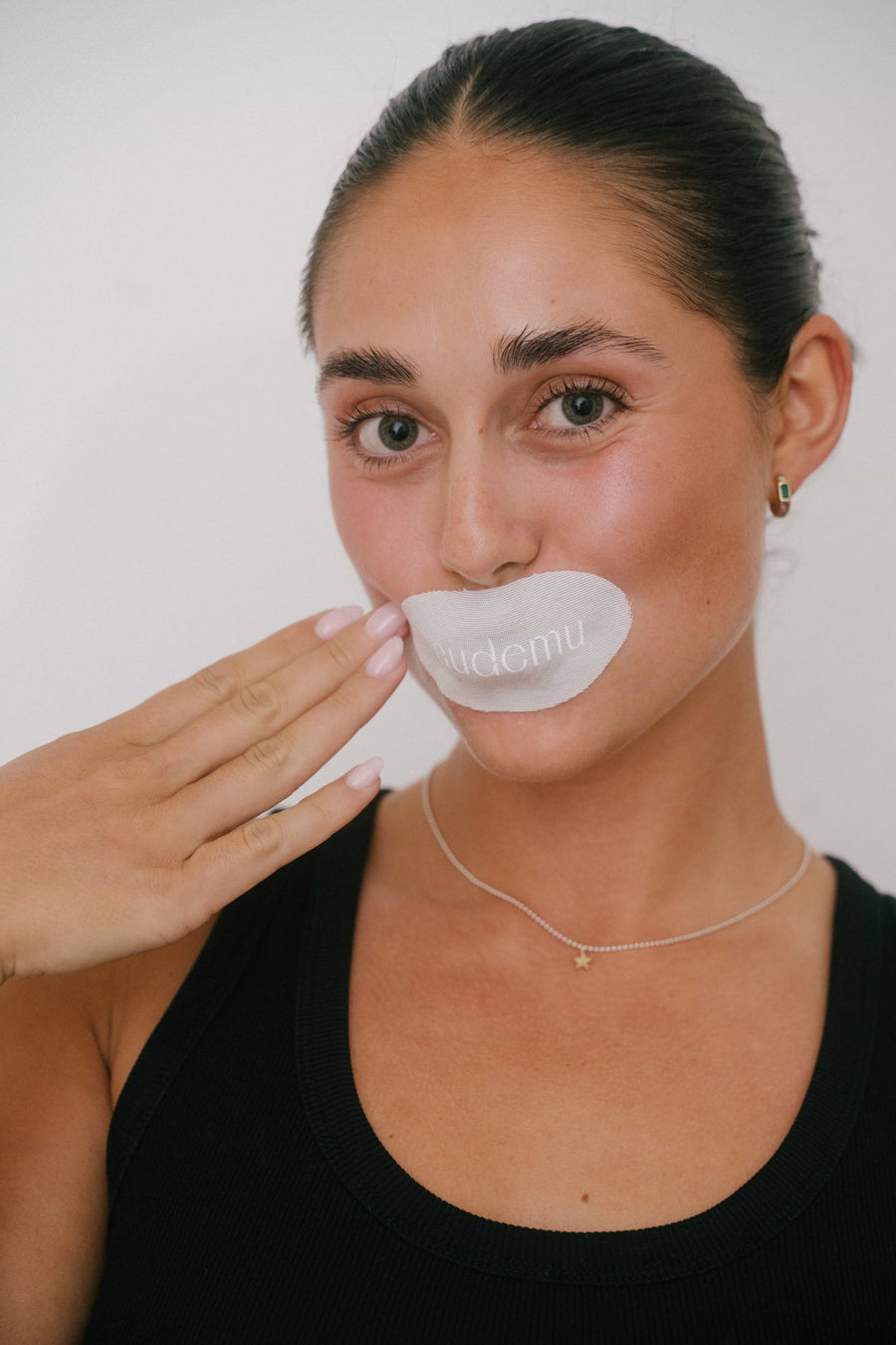Woman holding Audemu mouth tape applied to her lips, close-up product application