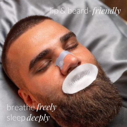 Bearded man sleeping with Audemu mouth tape and nasal strip, demonstrating comfortable nose breathing and beard-friendly sleep optimization products in a relaxed nighttime setting.